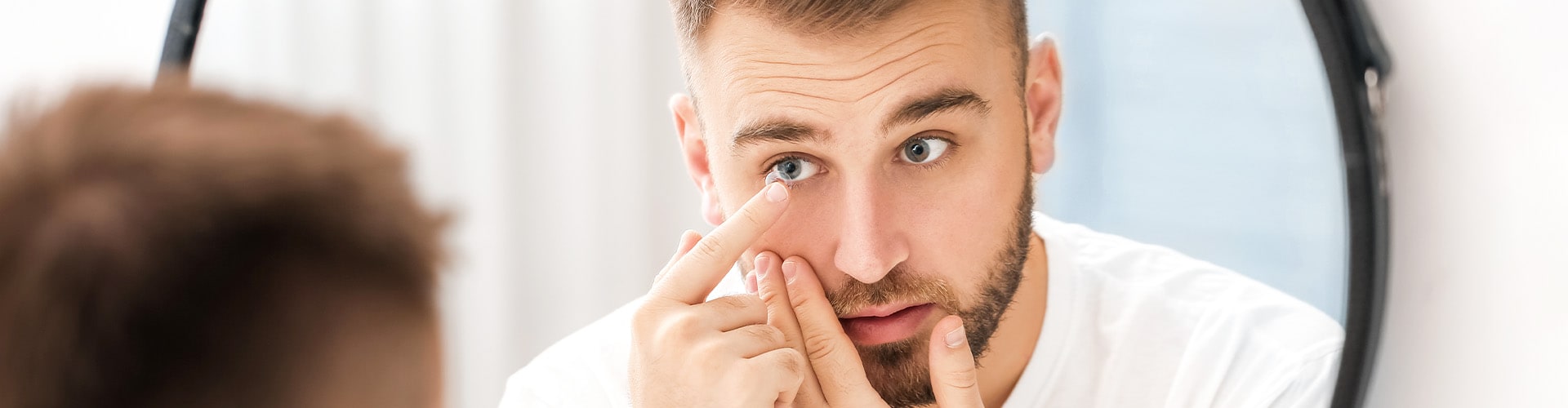 man putting in a contact lens
