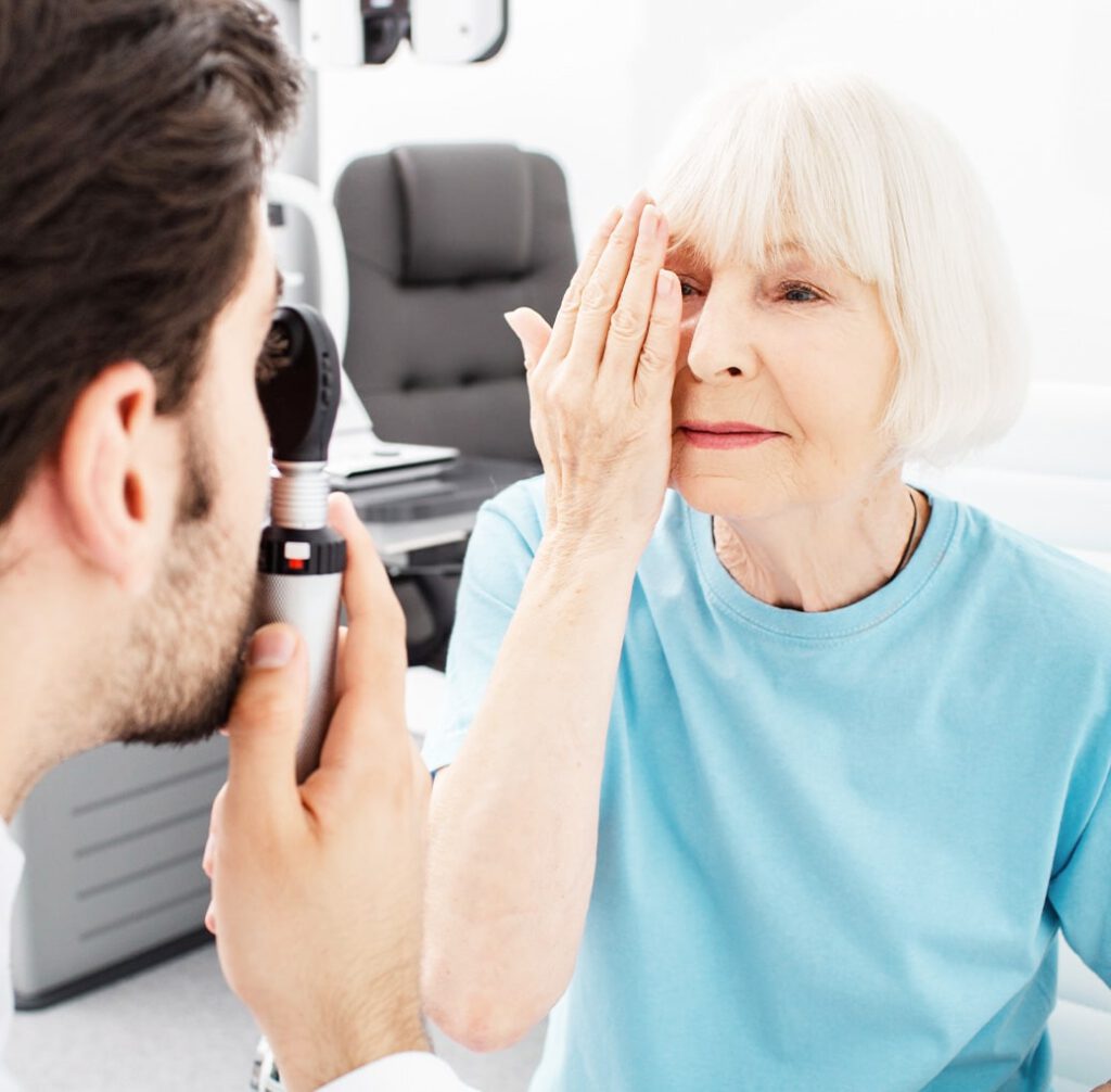An older woman receiving an eye exam from an optometrist.