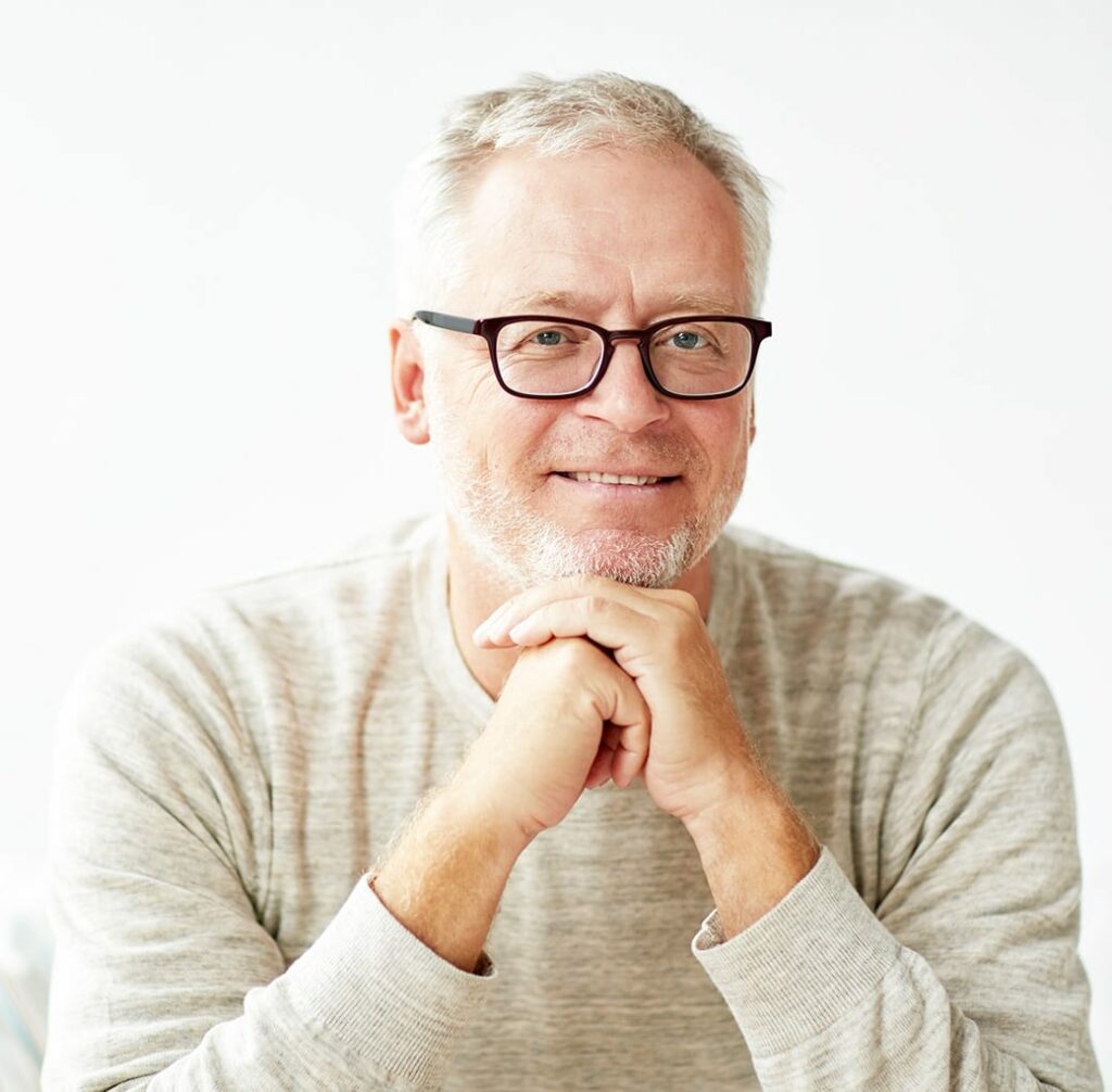 An older man wearing Neurolens and smiling at the camera.