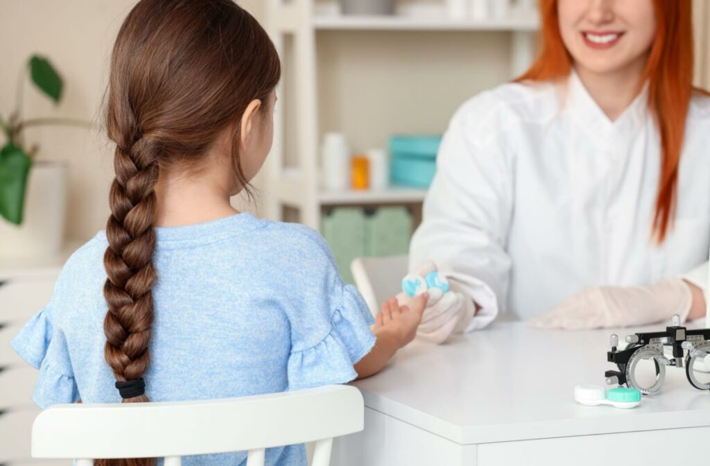 Girl receiving contact lenses from an optometrist during a pediatric eye care appointment
