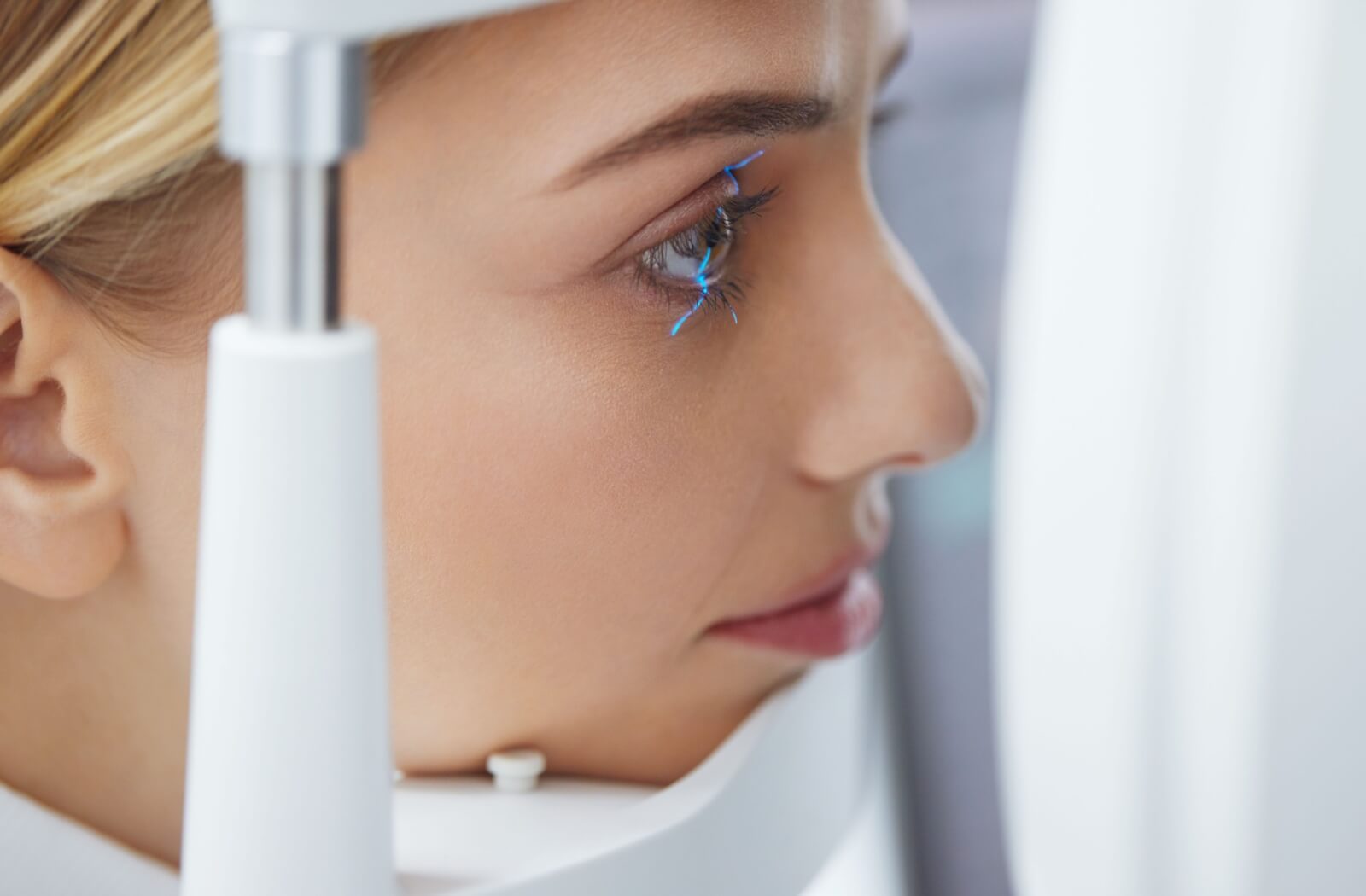 Patient undergoing an eye exam with a slit lamp machine.